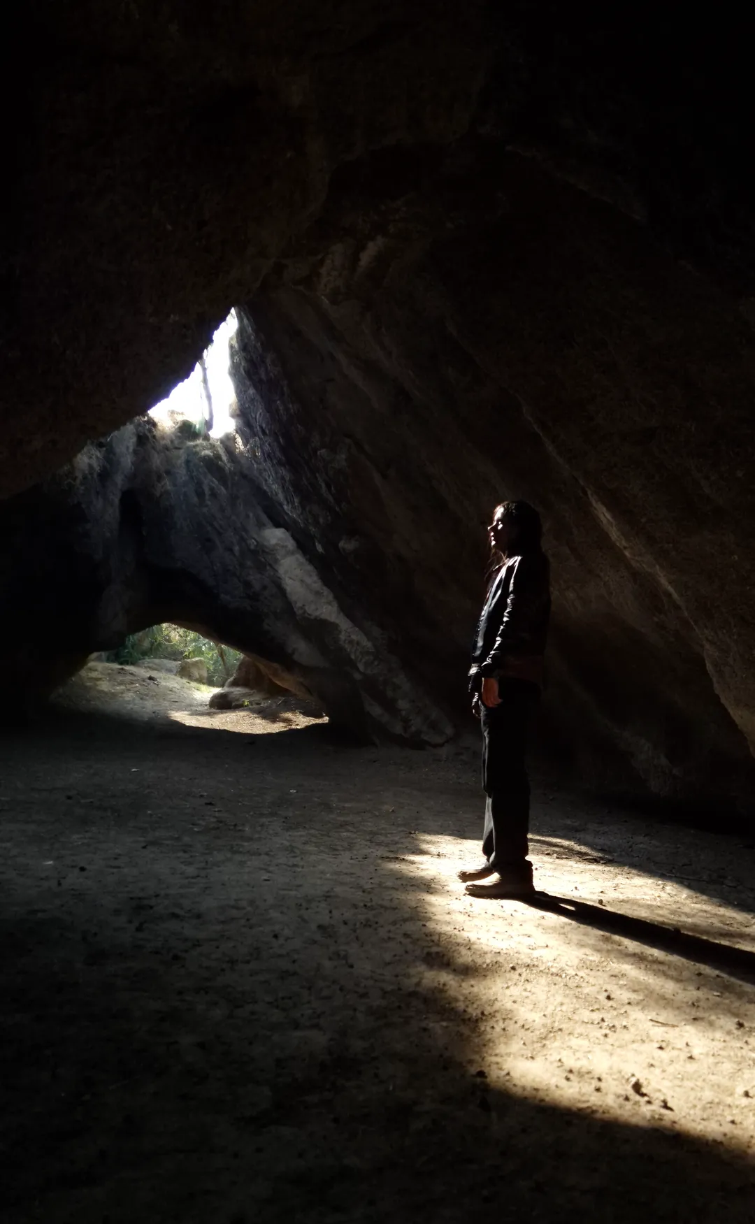 Gerard Reyes de pie dentro de una cueva, iluminado por un haz de luz natural que entra por una abertura en la roca, símbolo del Self-Authoring.