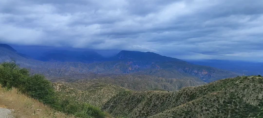 Camino de montaña tallado en la sierra árida bajo cielo nublado, evocando la carretera y el encuentro con uno mismo.