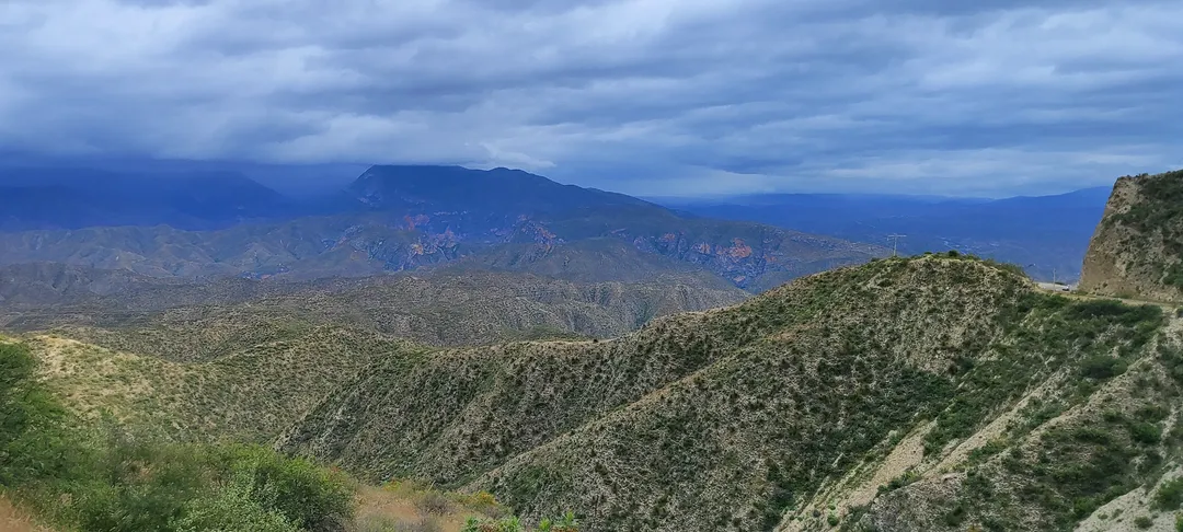 Camino de montaña tallado en la sierra árida bajo cielo nublado, evocando la carretera y el encuentro con uno mismo.