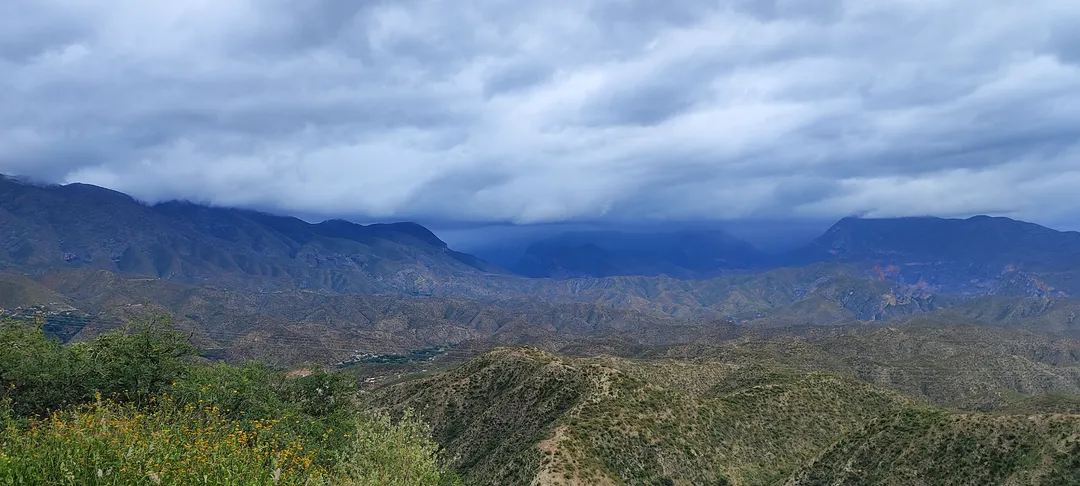 Camino de montaña tallado en la sierra árida bajo cielo nublado, evocando la carretera y el encuentro con uno mismo.