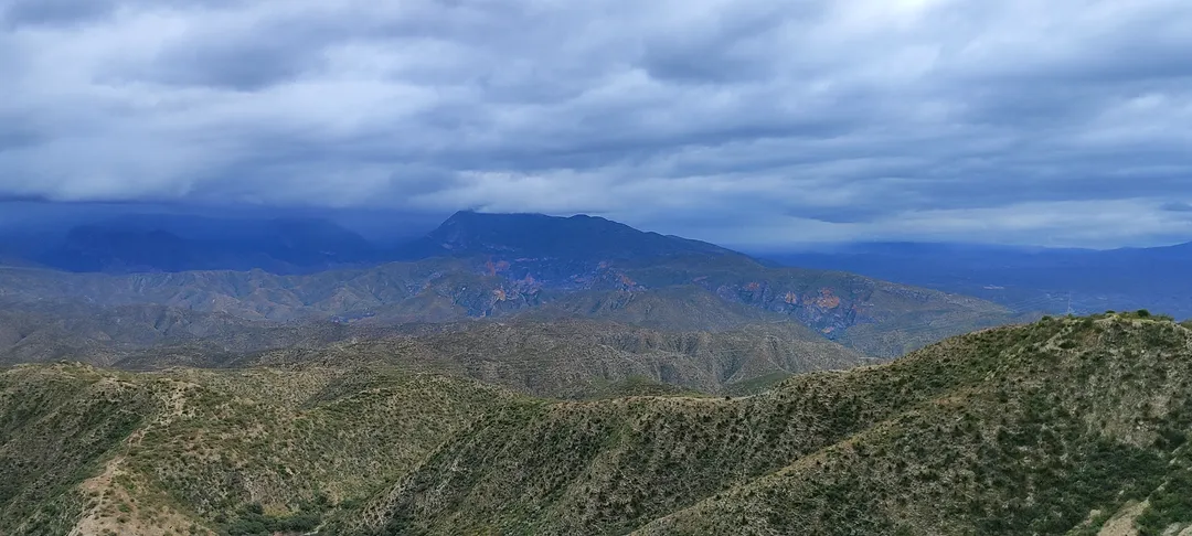 Camino de montaña tallado en la sierra árida bajo cielo nublado, evocando la carretera y el encuentro con uno mismo.