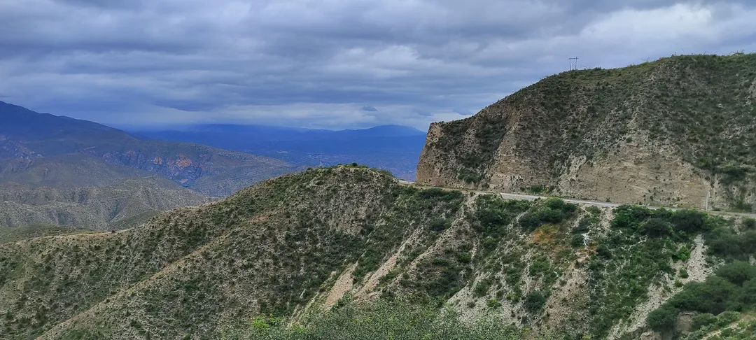 Camino de montaña tallado en la sierra árida bajo cielo nublado, evocando la carretera y el encuentro con uno mismo.
